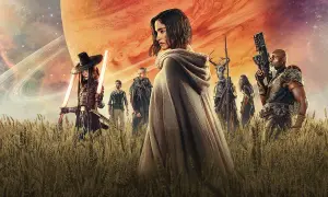 Un grupo de guerreros, incluyendo a una mujer con capa y espadas de luz, se alza en un campo de trigo bajo un cielo anaranjado y un planeta gigante. Son los rebeldes de Rebel Moon.