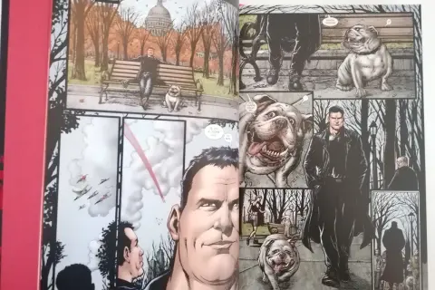 Los chicos en un parque otoñal, uno sentado en un banco con un bulldog, otro de pie con un perro.