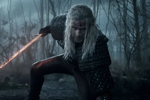 Geralt de Rivia, con su espada llameante, se prepara para la batalla en el bosque. ¡La **witcher temporada 5** promete acción!