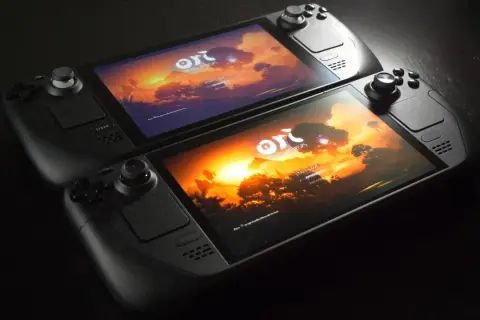 Dos Steam Deck 2 listos para jugar "Ori and the Will of the Wisps" con un atardecer vibrante.