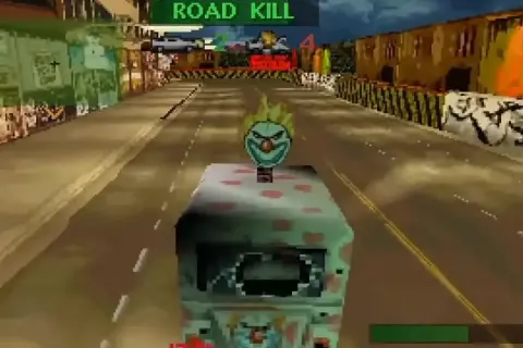 Vehículo con cara de payaso en una carrera de "Road Kill", rodeado de edificios y metal retorcido.
