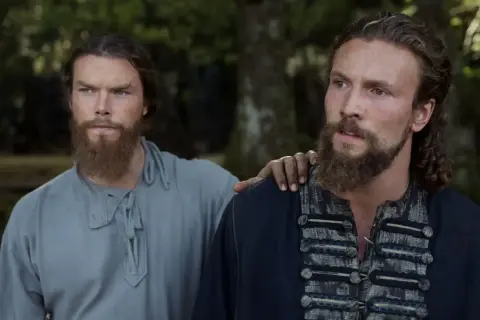 Dos guerreros vikingos, con barbas y miradas intensas, se preparan para la batalla, soñando con el Valhalla.