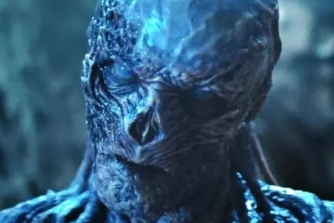 El rostro retorcido y azulado de Vecna, el villano de Stranger Things, con un ojo brillante y amenazante.