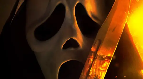 La máscara de Ghostface se acerca, con un cuchillo reflejando un incendio. El terror regresa en Scream 7.