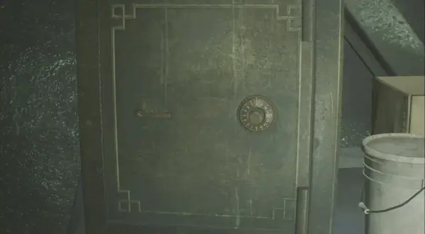 Caja fuerte verde con dial numérico y palanca, junto a un cubo blanco.