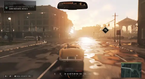 Conduciendo un coche clásico en una calle mojada, con el sol del atardecer iluminando la ciudad. El objetivo actual en Mafia 3 es eliminar a los asaltantes de Artie.