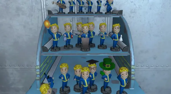 Colección de cabezones Fallout 4 en estantes, algunos sostienen objetos como un balón, una llave inglesa o un arma.