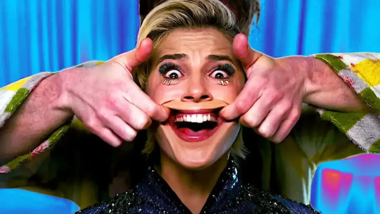 Manos estiran la boca de una mujer para crear una sonrisa forzada. Sus ojos están muy abiertos y maquillados.