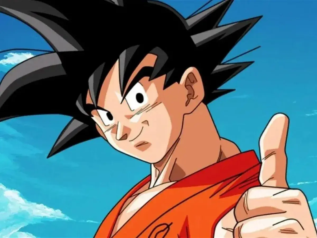 Goku, con su icónica ropa naranja y pulgar arriba, celebra el Goku Day bajo un cielo azul con nubes. ¡Un día para recordar!