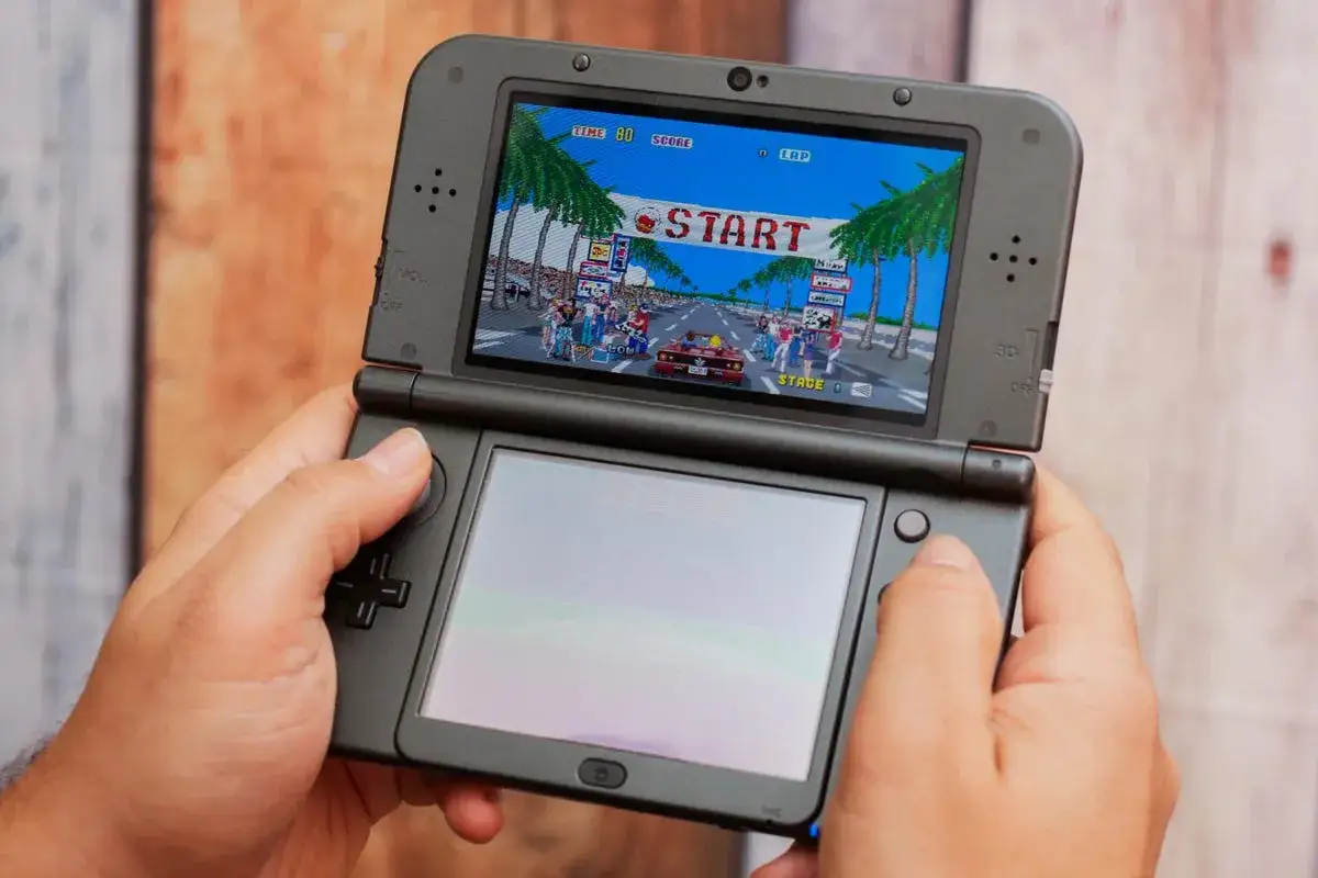 Manos sujetando una Nintendo 3DS, jugando a un juego de carreras retro. &iexcl;Diversi&oacute;n garantizada con estos juegos 3DS!