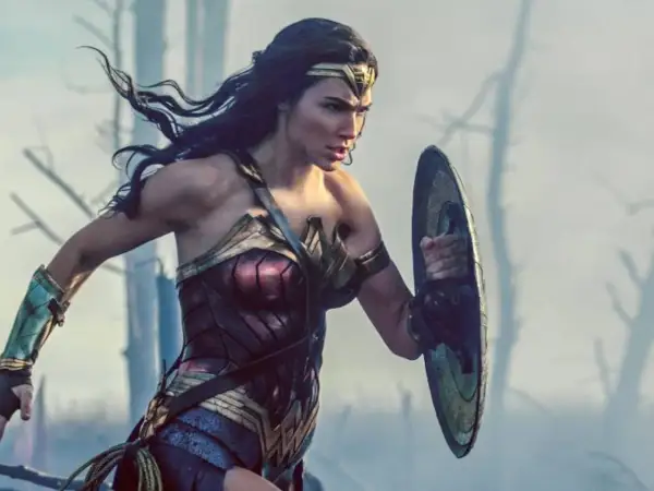 La heroína con el nombre de Wonder Woman, con su armadura icónica y escudo, se prepara para la batalla en un paisaje desolado.