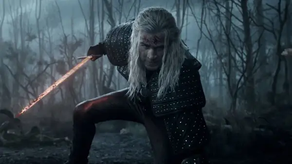Geralt de Rivia, con su espada llameante, se prepara para la batalla en el bosque. ¡La **witcher temporada 5** promete acción!